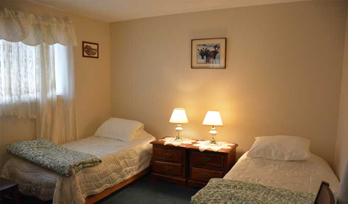 Guest room with two beds and bedside lamps